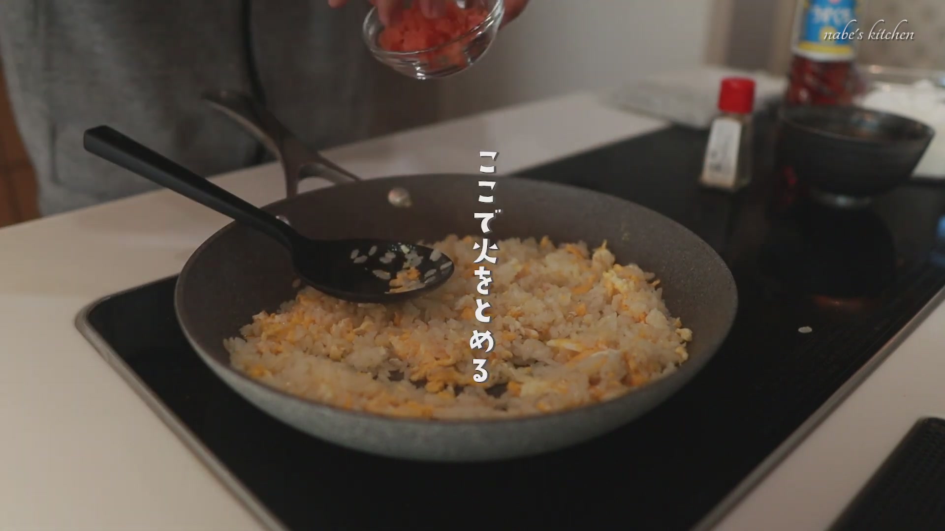 手順5：こしょうと味の素で味付けして、火を止めて明太子を散らして入れる