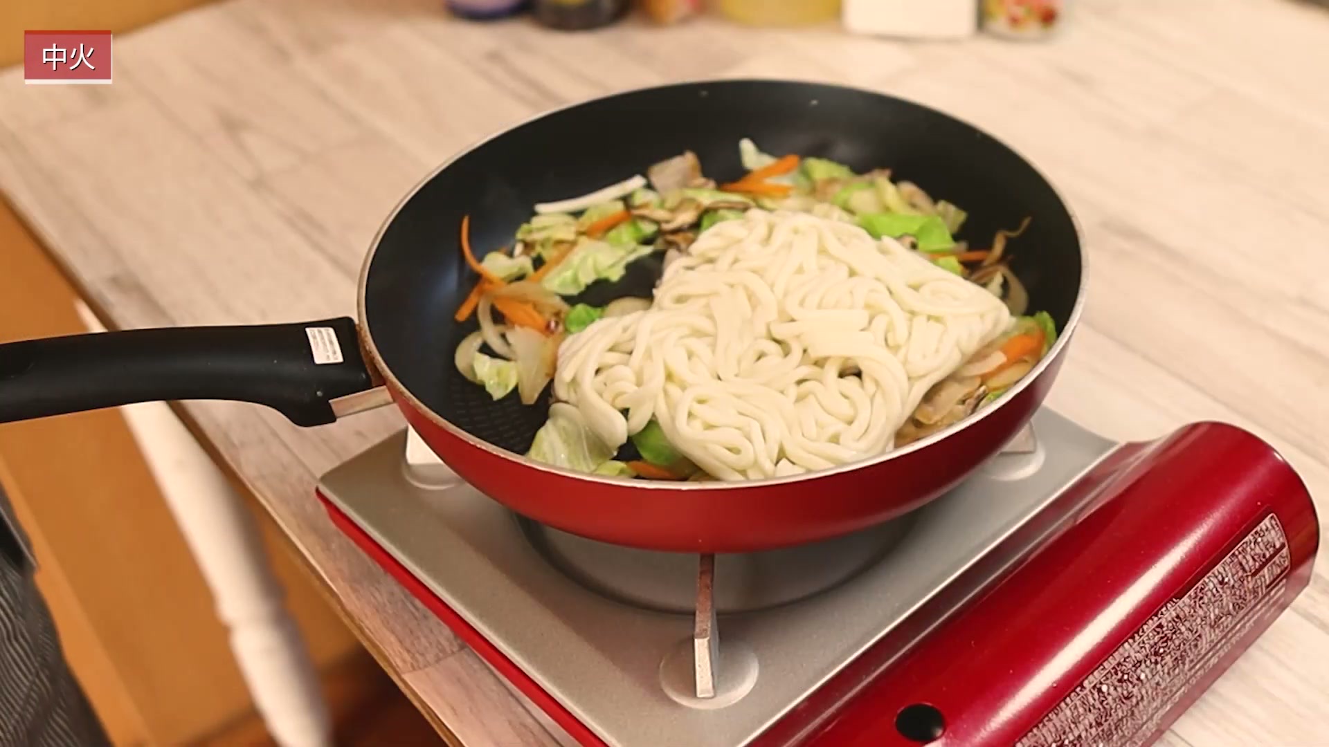 手順6:うどんを入れ、料理酒大さじ1を加えてほぐしながら炒める