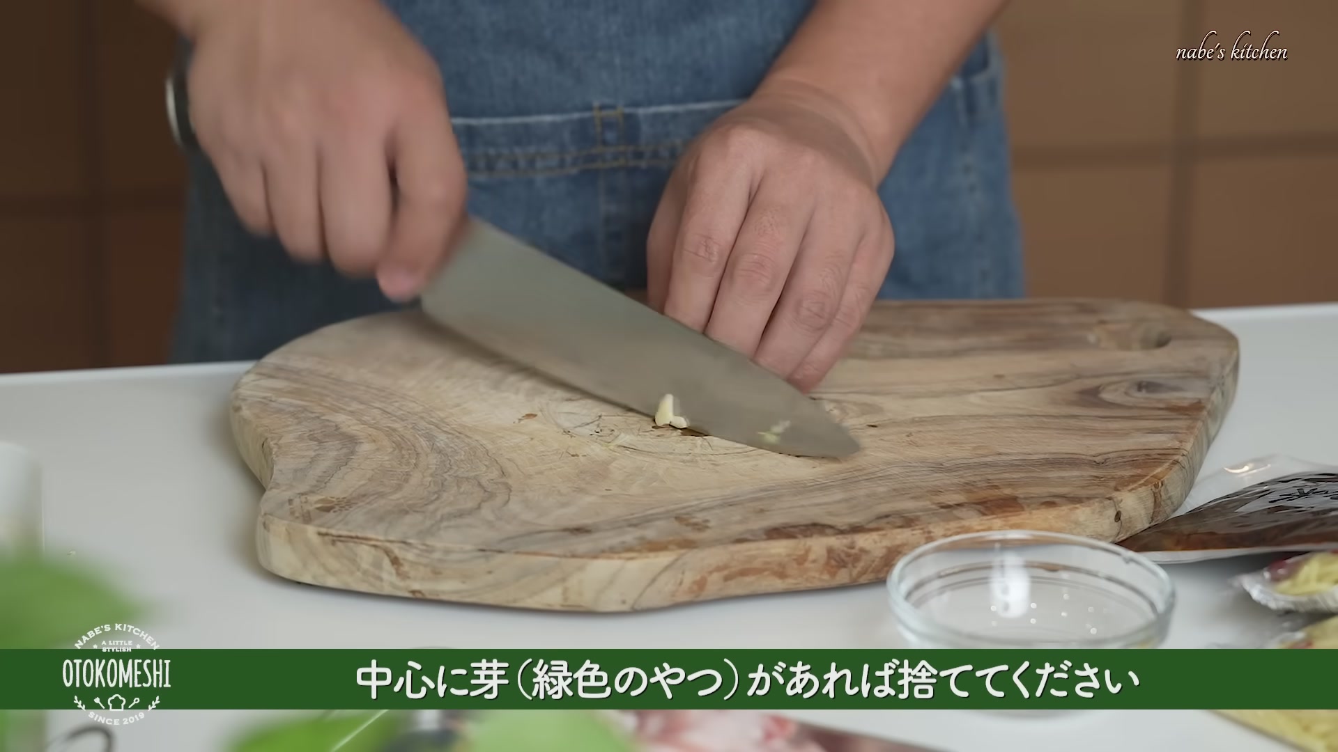手順1：にんにくは皮をむいて包丁の腹で潰し、芽があれば取り除いてから粗めのみじん切りにする