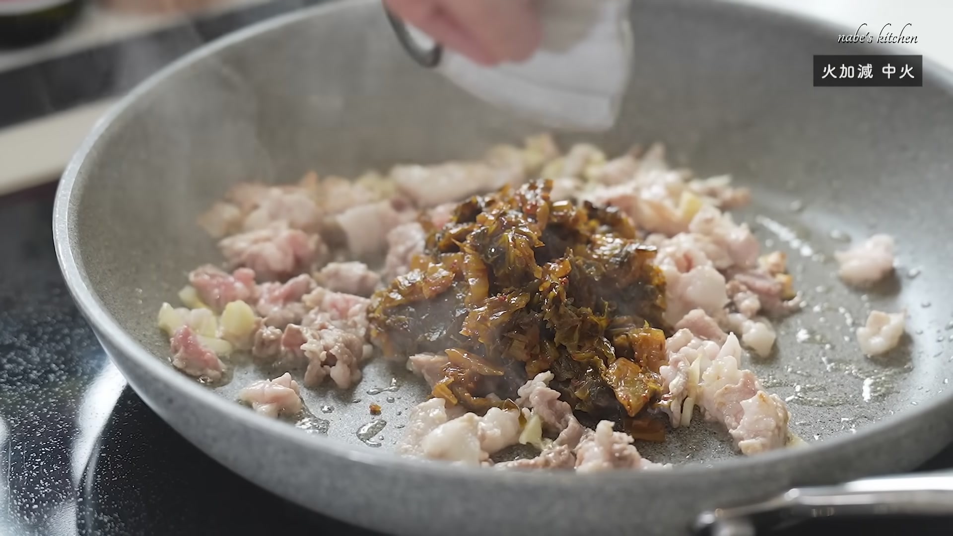 手順5：にんにくから香りが立ってきたら、豚こま肉と辛子高菜を加えて炒める