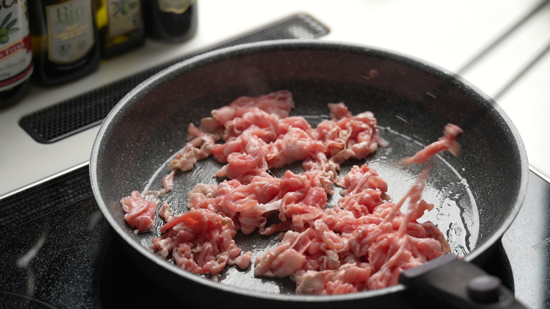 手順2：サラダ油をひいたフライパンで豚こま肉をほぐしながら炒め、塩コショウをする